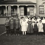 一些小小朋友和一名工作人员站立向Hont Elgin住宅学校前照片