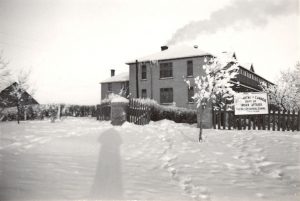 FileHills住宅校舍冬季裁雪 从烟囱冒出烟 从草坪对面取出 大标志