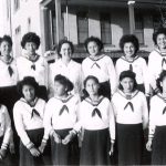 由12名身穿训练校服的加拿大女孩组成组,站在FileHills寄宿学校前拍相
