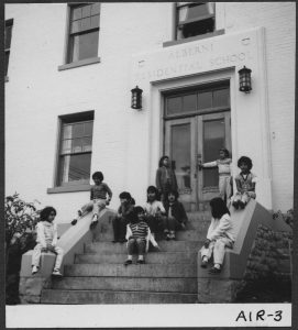 一群儿童坐在前台前门 Alberni寄宿学校刻上刻