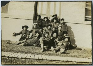 一群儿童坐在楼外草坪上